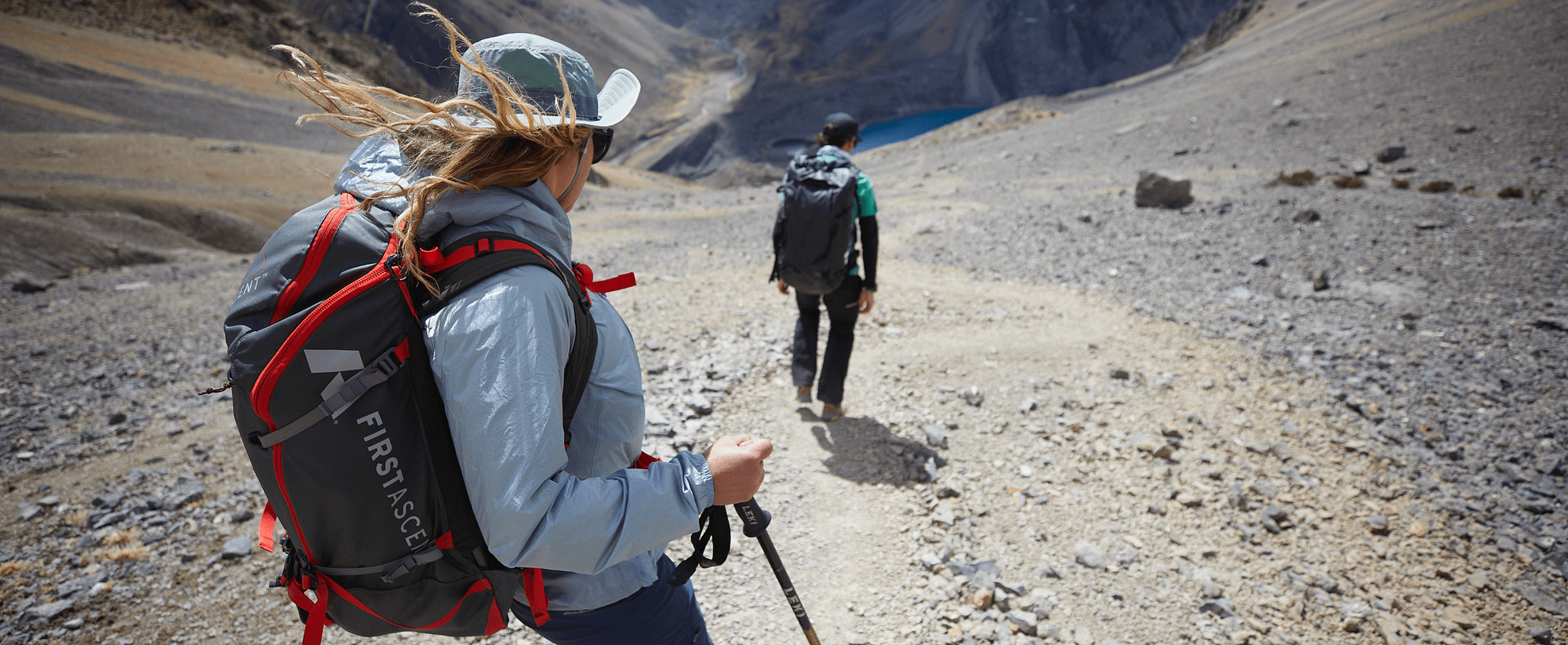 Two hikers in Eddie Bauer gear walk down a rocky mountainside