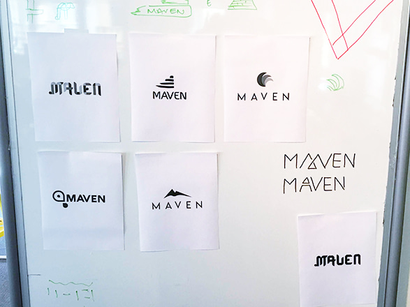 a series of logo ideas tapes to a whiteboard for design review