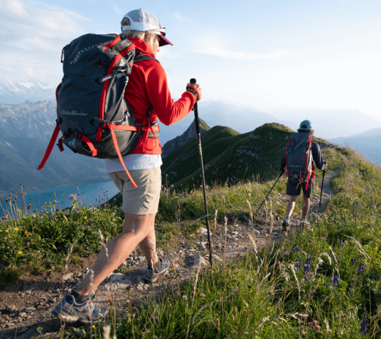 Two people hike a mountain ridge in Eddie Bauer gear