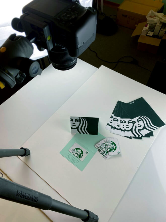 A camera on a tripod shooting photos of Starbucks business cards